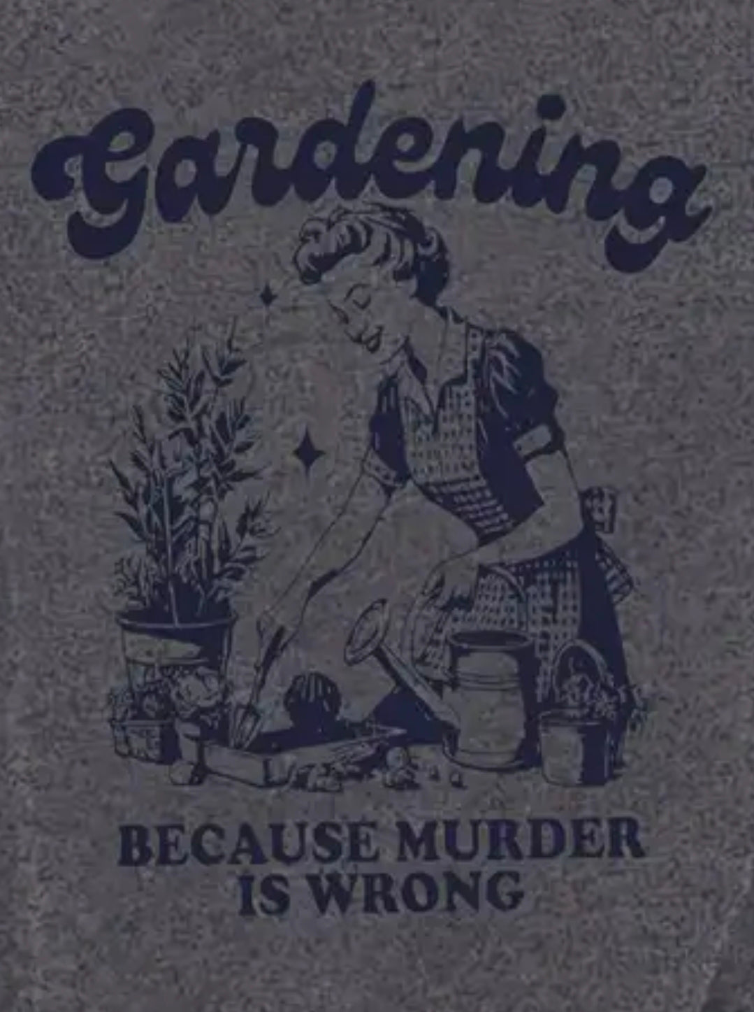 Gray t-shirt with a graphic of a person gardening and text 'Gardening Because Murder Is Wrong' on a textured gray background.