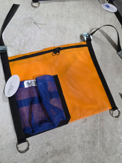Orange pouch with a blue mesh pocket on a concrete surface